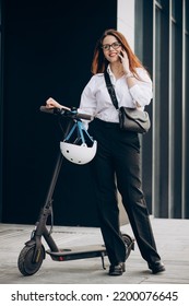 Young Business Woman Riding Scooter And Using Phone