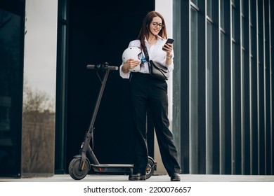 Young Business Woman Riding Scooter And Using Phone