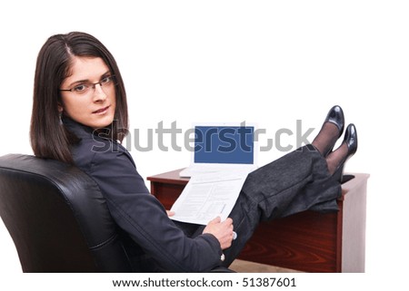 Young business woman seated with feet up on office desk.