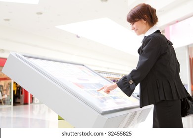 Young Business Woman Select 	Goods On Interactive Display