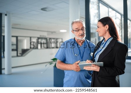 Young business woman shaking hand with elderly doctor.