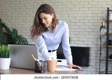 Young Business Woman Standing In Her Home Office Reading Notes.