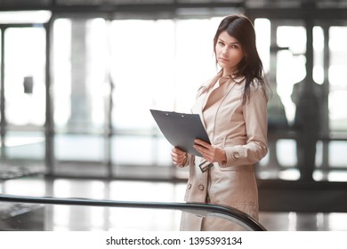 Young Business Woman Standing In Office Lobby.