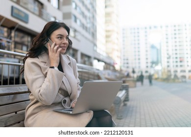 Young Business Woman Talking On Mobile Phone Working On Laptop Online Outside Office