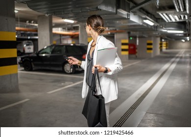 Young Business Woman Walking With Car Keys In The Underground Parking Of The New Residential Building