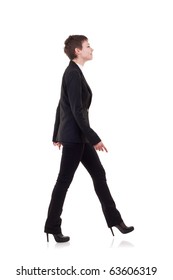 A Young Business Woman Is Walking. She Is Smiling And Looking Away From The Camera Isolated Over White Background