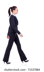 Young Business Woman Is Walking. She Is Smiling And Looking Away From The Camera Isolated Over White Background