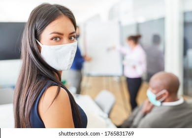 Young Business Woman Wearing A Face Mask Because Of Covid-19 And Corona Virus Giving A Presentation In The Office