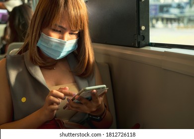 Mujer joven empresaria trabajando en un smartphone en un avión... mujer con mascarilla en un concepto de viaje en avión nuevo fondo normal. durante un brote de virus del coronavirus o covid-19