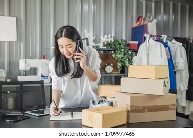 Young business woman working online e-commerce shopping at her shop. Young woman seller prepare parcel box of product for deliver to customer. Online selling, e-commerce. - Shutterstock ID 1709977465