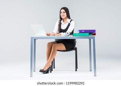 Young business woman at working table work on laptop on gray background - Shutterstock ID 1199982292