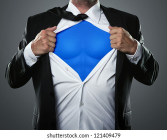 Young businessman acting like a super hero and tearing his shirt off with copy space