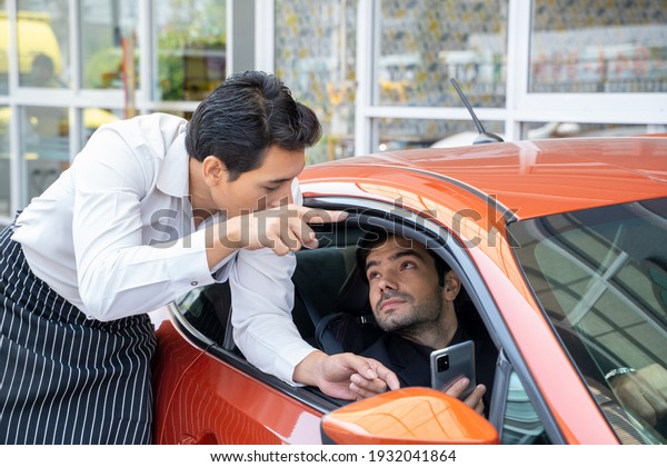 A young businessman asking staff for directions to\
the parking lot