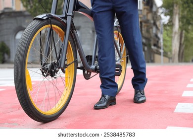 Young businessman with bicycle crossing road on city street, closeup - Powered by Shutterstock