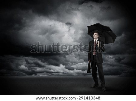 Young businessman in black suit with umbrella