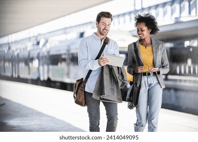 Young businessman and businesswoman using tablet together at the train station - Powered by Shutterstock