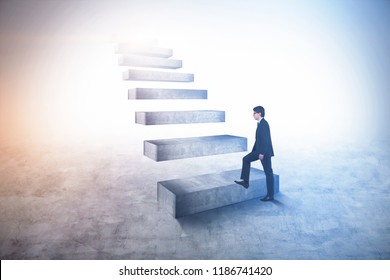 Young businessman climbing giant career ladder. Business lifestyle and leadership concept. Toned image copy space