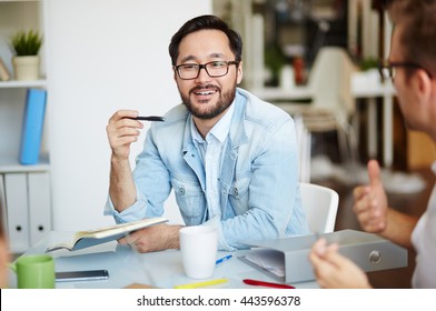 Young businessman communicating with his colleague at the table - Shutterstock ID 443596378