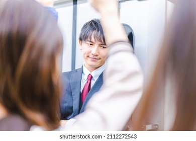 Young Businessman Commuting On A Crowded Train