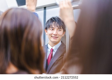 Young Businessman Commuting On A Crowded Train