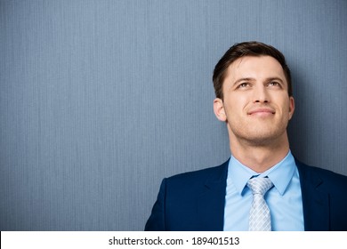 Young Businessman Deep In Thought Standing Leaning Against A Clean Blackboard Staring Up Into The Air As He Tries To Come Up With A Solution To A Problem, With Copyspace