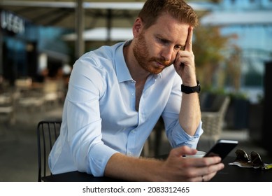 Young Businessman Drinking Coffee In Cafe. Upset Man Using The Phone