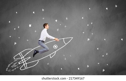 Young Businessman Flying In Sky On Drawn Rocket