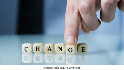 Young businessman hand creates the word "Change" of the wooden letter blocks . Concept of financial market and future of stock market business.
