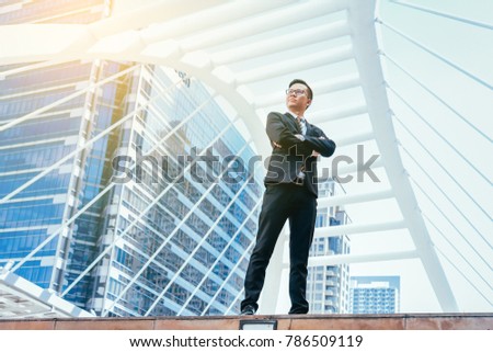 Young businessman handsome who standing in feeling commitment to doing business with cityscape background.