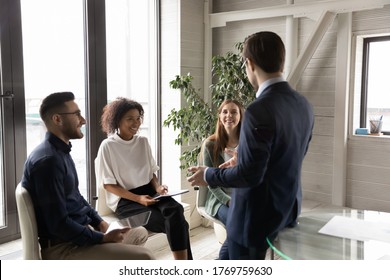 Young businessman head lead team casual briefing with smiling multiracial colleagues in office, male boss leader talk brainstorm with happy diverse coworkers at group meeting in boardroom together - Shutterstock ID 1769759630