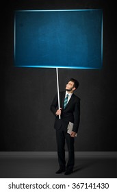 Young businessman holding a big, blue board - Shutterstock ID 367141430