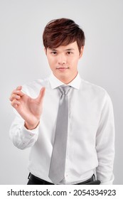 Young Businessman Holding Imaginary Object Over White Background