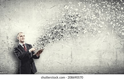 Young businessman holding tablet pc and letter flying in air