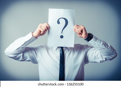 Young businessman holding a white billboard with a question mark on it - Powered by Shutterstock