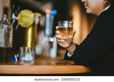 A young businessman holds a glass of whiskey, toasting with friends at an upscale bar. The scene captures the essence of luxury and celebration, with a focus on camaraderie and the nightlife atmospher - Powered by Shutterstock