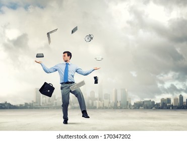 Young businessman juggling with business items against urban scene - Powered by Shutterstock