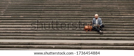  young businessman with laptop sitting on stairs ramp