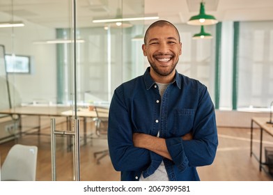 Young businessman laughing while standing in a modern office - Shutterstock ID 2067399581