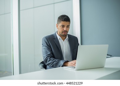 Young businessman lawyer with laptop, alone in big bright conference room. - Shutterstock ID 448521229