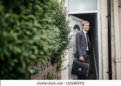 Young businessman leaving the house to commute to work.
