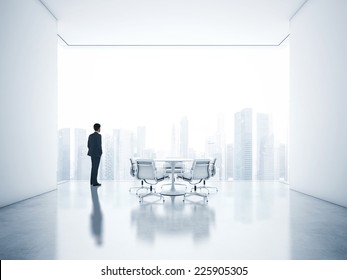 Young businessman looking at city through window