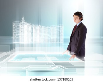 Young Businessman Looking At High-tech Image Of Building Model