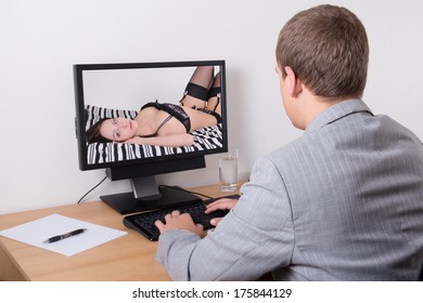 young businessman looking at sexy woman in computer at work