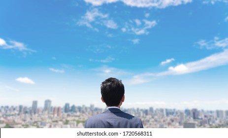 Young Businessman Looking Up At Sky