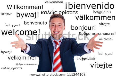 Young businessman makes a welcome gesture on a multilingual background