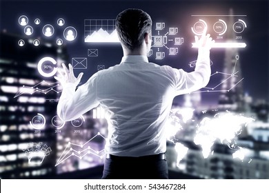 Young businessman managing business charts on illuminated night city background. Management concept - Powered by Shutterstock - Get 15% off with code: PIKWIZARD15