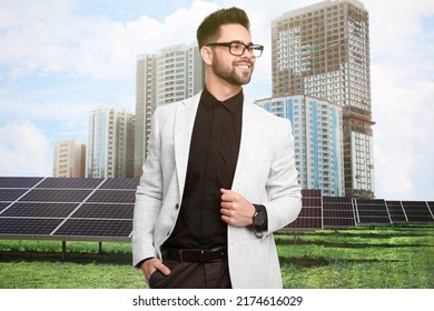 Young businessman near solar panels and beautiful view of cityscape. Alternative energy source - Powered by Shutterstock