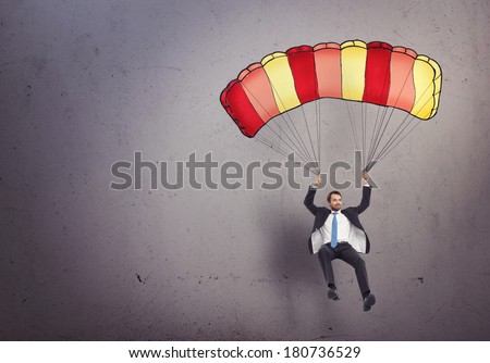 Young businessman with parachute