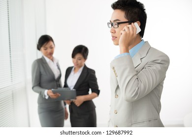 Young businessman with phone on the foreground