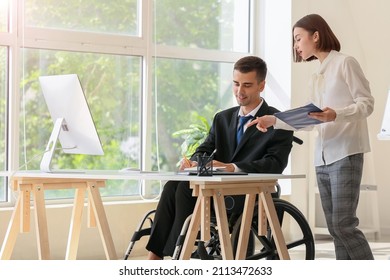 Young Businessman With Physical Disability And His Secretary In Office